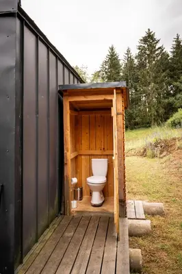 a toilet sitting inside of a wooden out house at Tiny House Sedla in Velká