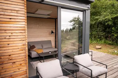 a screened in porch with two chairs and a couch at Tiny House Sedla in Velká