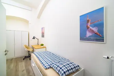 a bedroom with a bed and a painting of a ballet dancer at Sokol House New Town in Prague