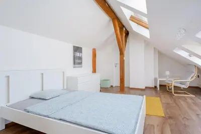 a white bedroom with a bed and a desk at Sokol House New Town in Prague