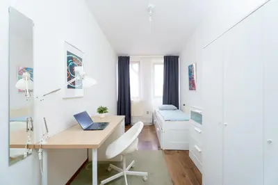 a white room with a desk and a bed at Sokol House New Town in Prague