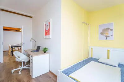 a small bedroom with a bed and a desk at Sokol House New Town in Prague
