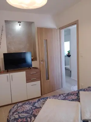 a bedroom with a bed and a flat screen tv at Apartmán Maria in Litoměřice