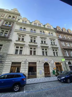 a large building with cars parked in front of it at Cozy Luxe Home at the Heart of Old Prague Centre in Prague
