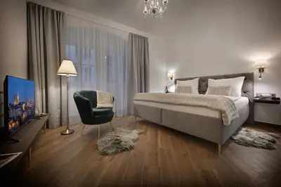 a kitchen with a wooden table with chairs and a sink at Kaiserstein Palace Apartments in Prague