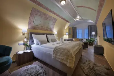 a bedroom with a large bed and a fireplace at Kaiserstein Palace Apartments in Prague