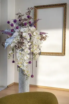 a vase filled with flowers in front of a mirror at Hotel Junior Poděbrady in Poděbrady