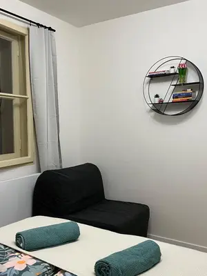 a room with a chair and a clock on the wall at Modern apartment in Zizkov 10 min from Wenceslav Square in Prague