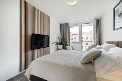 a bedroom with a bed and a tv on a wall at Boutique apartment Záhřebská in Prague