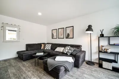 a living room with a leather couch and a table at Boutique apartment Záhřebská in Prague