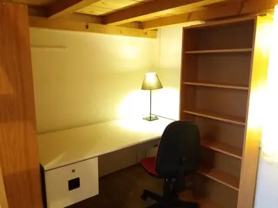 a bedroom with a desk with a lamp and a chair at Only Female Bedroom in a share flat in vinohrady in Prague