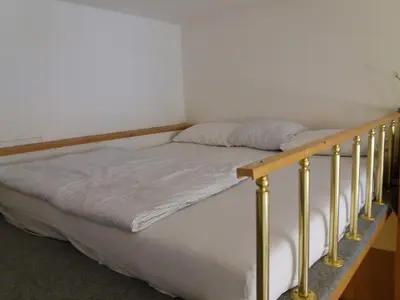 a bed in a room with a wooden bed frame at Only Female Bedroom in a share flat in vinohrady in Prague