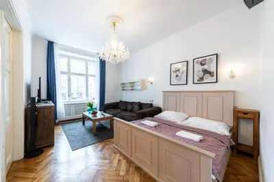 a bedroom with a large bed and a couch at Dušní Street Gem in Prague