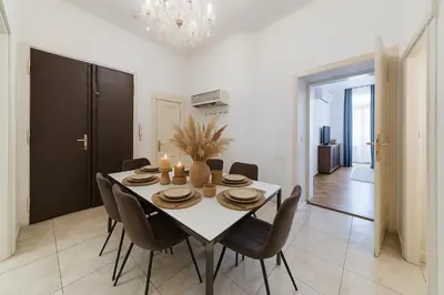 a dining room with a white table and chairs at Dušní Street Gem in Prague