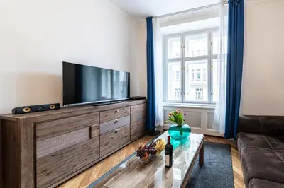 a living room with a flat screen tv on a dresser at Dušní Street Gem in Prague