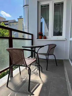 a patio with two chairs and a table on a balcony at A large 1 bedroom apartment with an available private parking in Prague