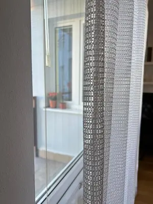 a glass curtain in front of a window at A large 1 bedroom apartment with an available private parking in Prague