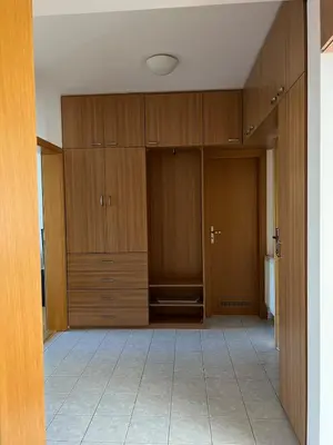 an empty room with wooden cabinets and a tile floor at A large 1 bedroom apartment with an available private parking in Prague