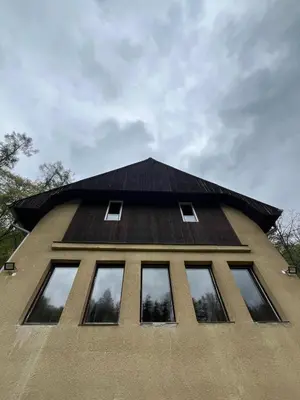 a building with a black roof and windows at Kolečko in Křivoklát