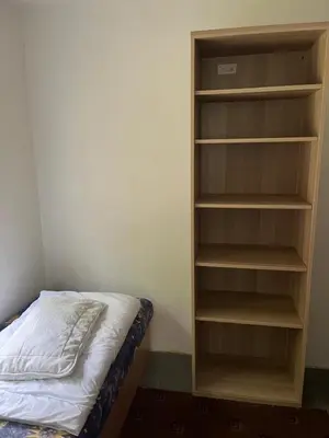 a bedroom with a book shelf next to a bed at Kolečko in Křivoklát