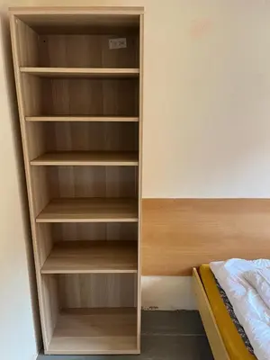 a closet with wooden shelves next to a bed at Kolečko in Křivoklát