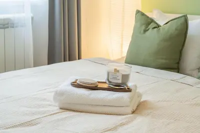a tray with a candle and towels on a bed at HOMELY I Central 38m2 APT I ELEVATOR I Self Check-In in Prague