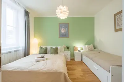 a bedroom with two beds and a chandelier at HOMELY I Central 38m2 APT I ELEVATOR I Self Check-In in Prague