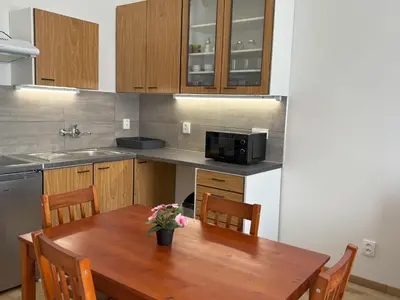 a kitchen with a wooden table with flowers on it at Prague Deluxe City Center Apartment in Prague