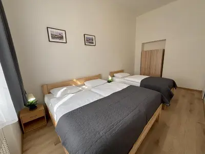 two beds in a small bedroom with two lamps at Prague Deluxe City Center Apartment in Prague
