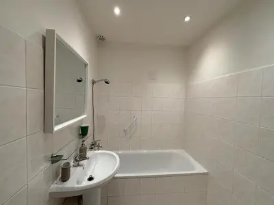 a white bathroom with a tub and a sink at Prague Deluxe City Center Apartment in Prague