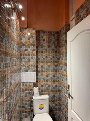 a bathroom with a toilet and a tiled wall at VIP 1-Wenceslas square in Prague