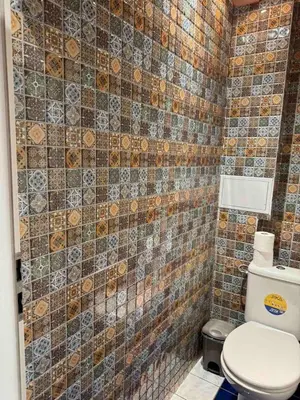 a bathroom with a toilet and a tiled wall at VIP 1-Wenceslas square in Prague