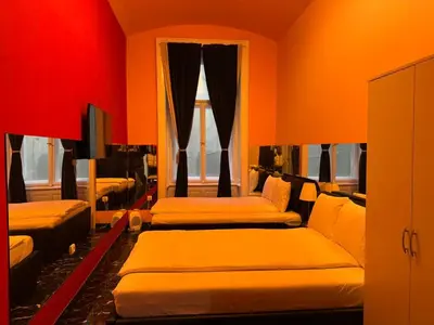 a room with four beds and a red wall at VIP 1-Wenceslas square in Prague