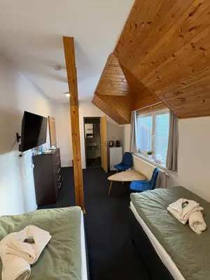 a room with two beds and a tv in it at Dvůr Stupice