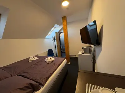 a bedroom with a bed and a flat screen tv at Dvůr Stupice