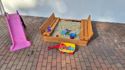 a wooden sandbox with toys in the sand at Hotel Radnice Dobrovice in Dobrovice