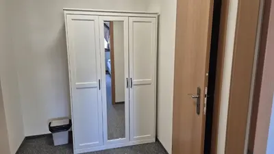 a white cabinet with a mirror in a room at Hotel Radnice Dobrovice in Dobrovice