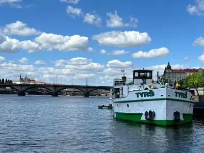 a boat in the water with a bridge in the background at Home By The River in Prague