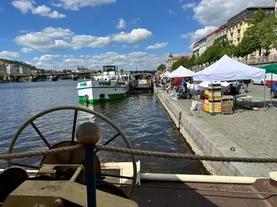 a boat is docked next to a river with tents at Home By The River in Prague