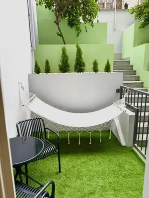 a patio with a hammock and a table and chairs at Museum Garden Stay in Prague