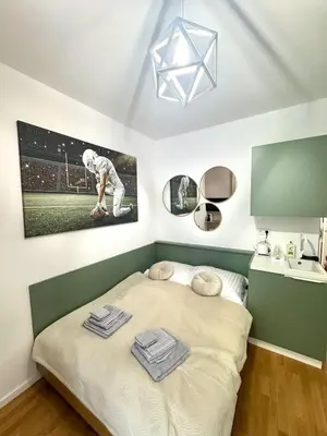 a small bedroom with a bed and a sink at Museum Garden Stay in Prague