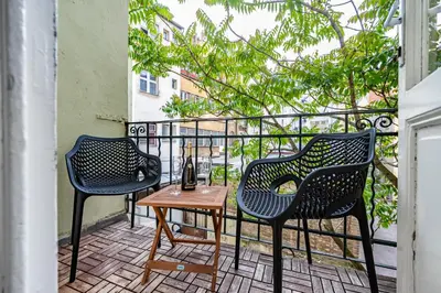 two chairs and a table on a balcony at Baroque Grand Apartment XXL - City Center - 160 m2 in Prague