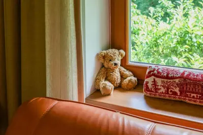 a teddy bear sitting on a window sill at Beautiful house by the river with its own dock in Rabyně