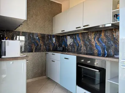 a kitchen with white cabinets and a black oven at Old town view BOUTIQUE APARTMENT with FREE PARKING in Prague