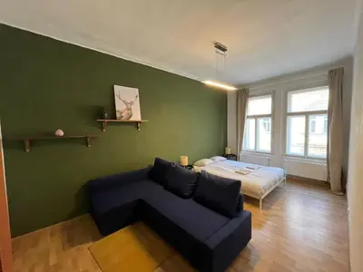 a living room with a couch and a bed at Skyline Nest on Borivojova in Prague