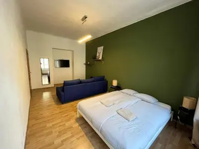 a bedroom with a bed and a blue couch at Skyline Nest on Borivojova in Prague