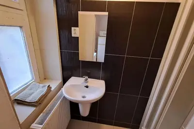 a small bathroom with a sink and a mirror at Skyline Nest on Borivojova in Prague