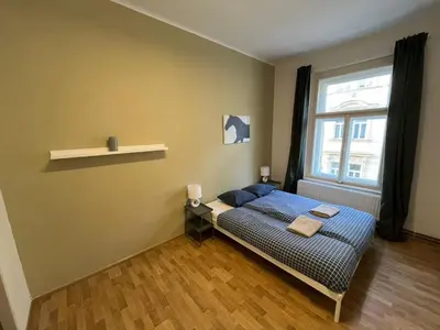 a small bedroom with a bed and a window at Skyline Nest on Borivojova in Prague