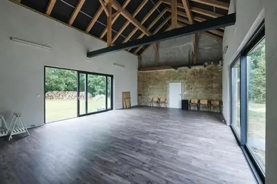 a large room with a wooden floor and large windows at Hájovna u Bažantnice in Pěčice