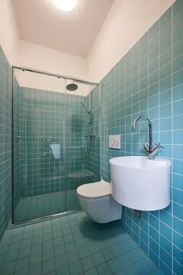 a blue tiled bathroom with a sink and a toilet at Hájovna u Bažantnice in Pěčice